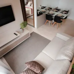 Nowoczesna suterena z salonem, jadalnią i sypialnią. Jasne kolory, minimalistyczne meble i dużo światła.