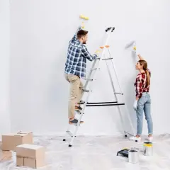 Para odnawia mieszkanie za remont. Malują ściany na biało, on na drabinie, ona obok.