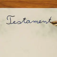 Pisanie atramentowym piórem słowa "Testament" na papierze. To ważny dokument, testament allograficzny, który wymaga precyzji.
