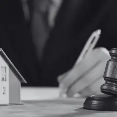Model domu i młotek sędziowski symbolizują sprawę o reklamację z tytułu rękojmi.