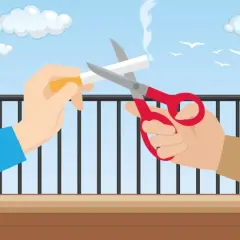 Dwie ręce przecinają nożyczkami papierosa na balkonie. Czy można palić na balkonie? Ta ilustracja sugeruje, że nie.