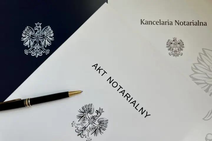 Długopis leży na dokumencie "AKT NOTARIALNY" z godłem Polski. To ważny krok do zawarcia **umowy przyrzeczonej**.