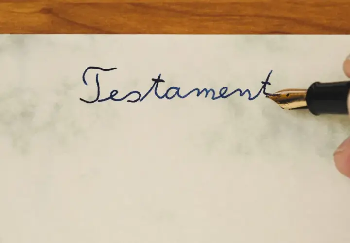 Pisanie atramentowym piórem słowa "Testament" na papierze. To ważny dokument, testament allograficzny, który wymaga precyzji.
