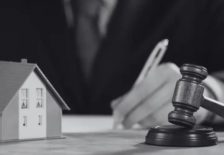 Model domu i młotek sędziowski symbolizują sprawę o reklamację z tytułu rękojmi.