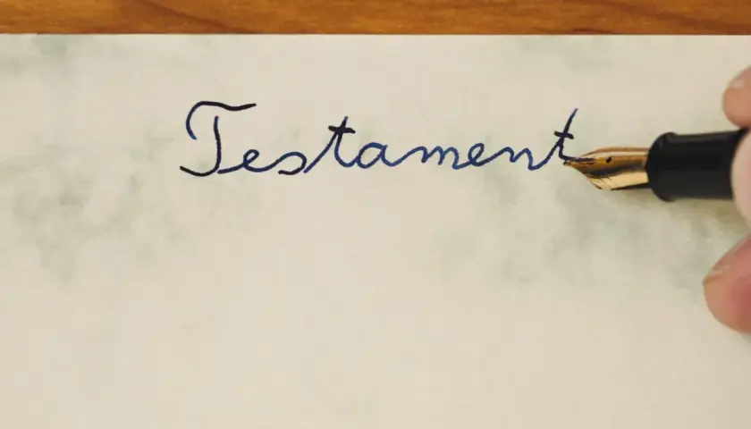 Pisanie atramentowym piórem słowa "Testament" na papierze. To ważny dokument, testament allograficzny, który wymaga precyzji.