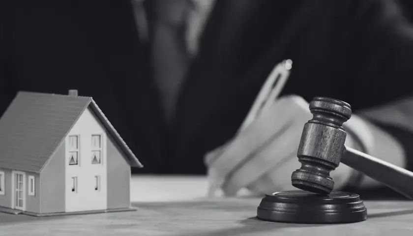 Model domu i młotek sędziowski symbolizują sprawę o reklamację z tytułu rękojmi.