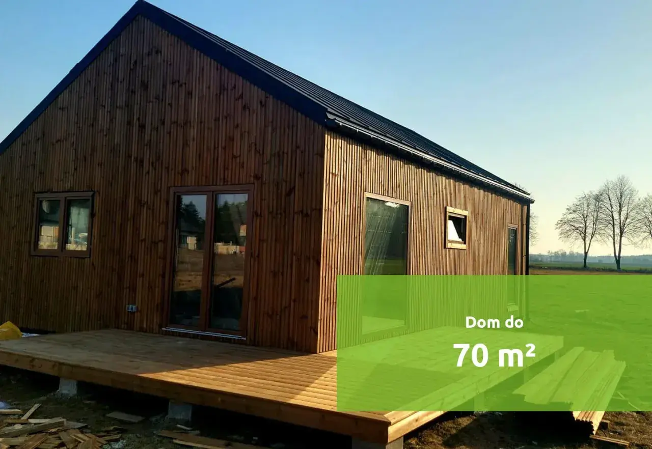 Drewniany dom z tarasem i zielonym polem z napisem "Dom do 70 m²".