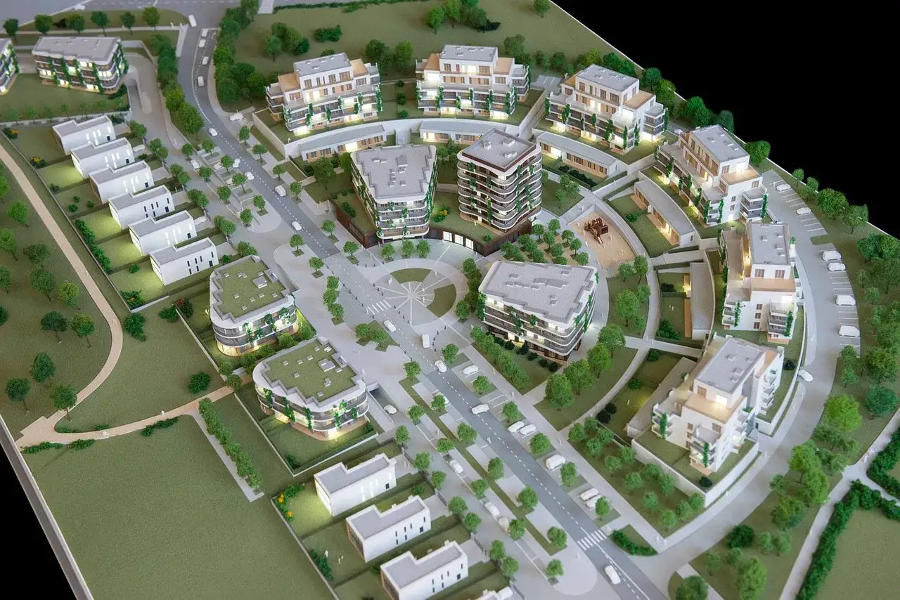 Model osiedla mieszkaniowego, pokazujący przemyślane zagospodarowanie przestrzenne z budynkami, drogami i zielenią.