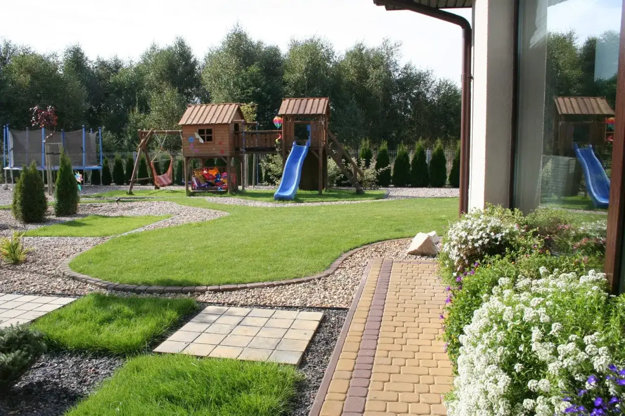 Piękny ogród z domkiem, zjeżdżalnią i trampoliną. Czy taki plac zabaw wymaga pozwolenia na budowę?
