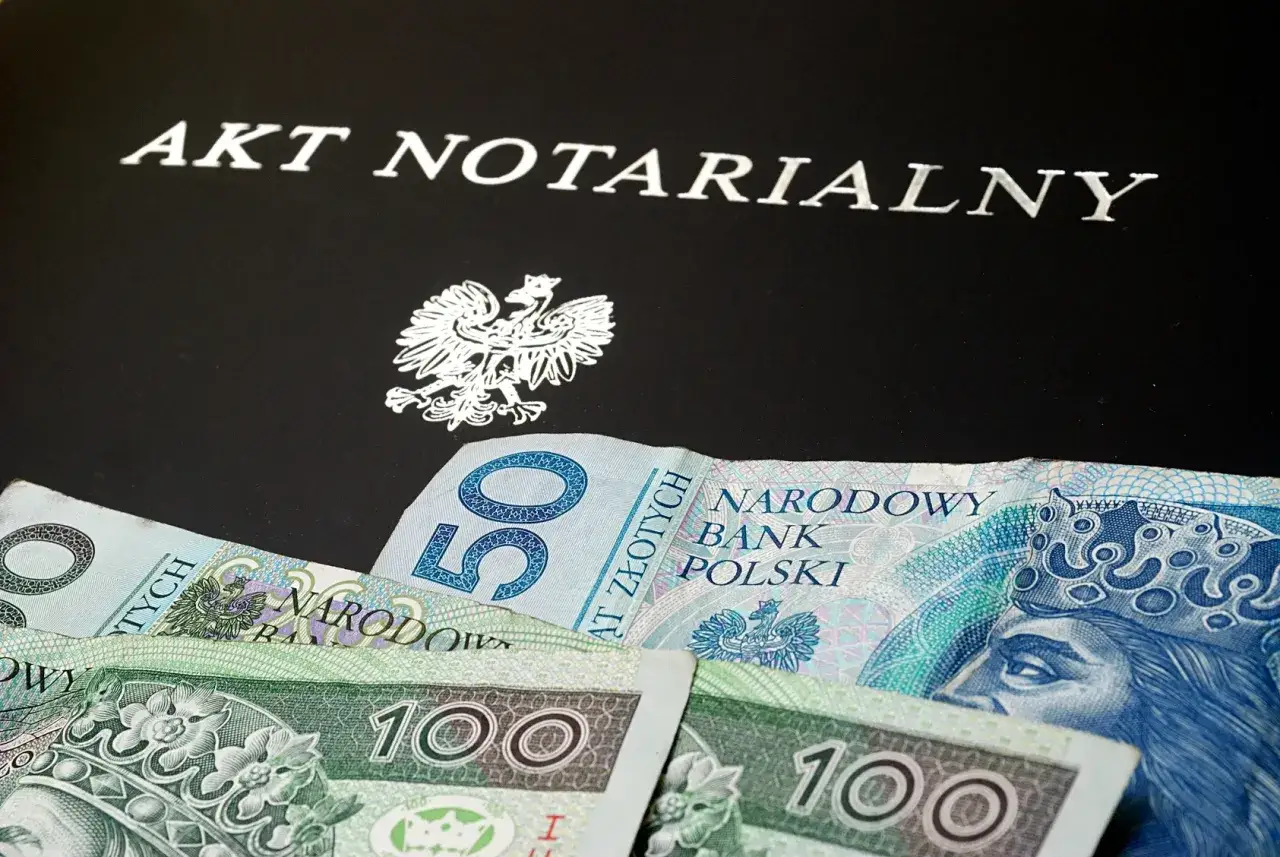 Akt notarialny i polskie banknoty. Dokumenty i pieniądze symbolizują kwestie prawne, takie jak podatek od darowizny w rodzinie.