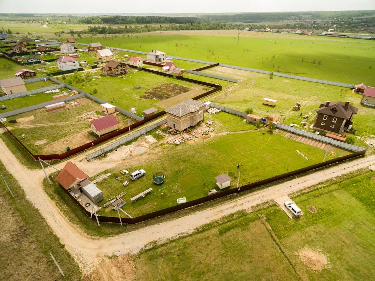 Osiedle domów w budowie, z drogą dojazdową i infrastrukturą, gdzie służebność drogi jest kluczowa dla rozwoju.